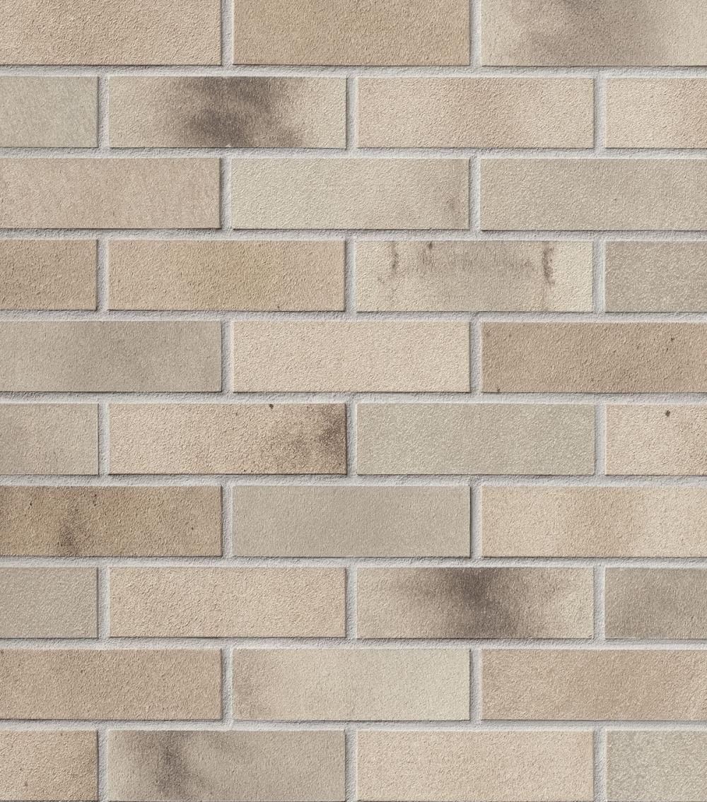 Beige Ziegelwand mit unregelmäßigen dunklen Schattierungen.