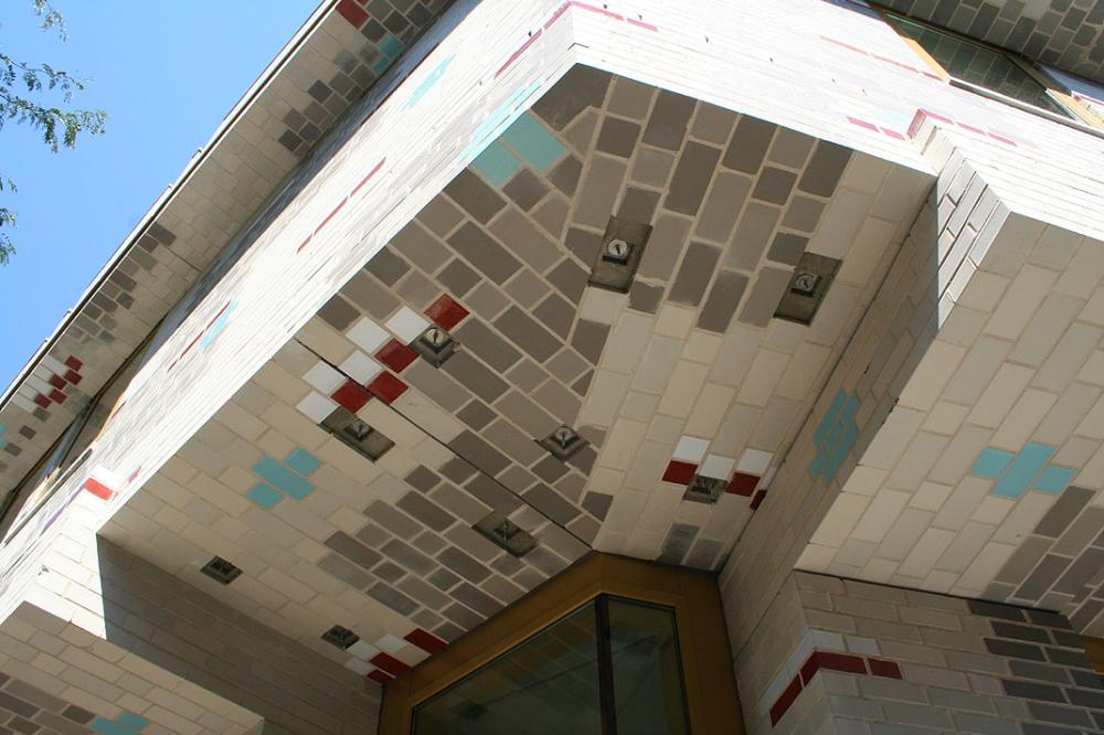 Moderne Gebäudefassade mit bunten Kacheln in geometrischen Mustern.