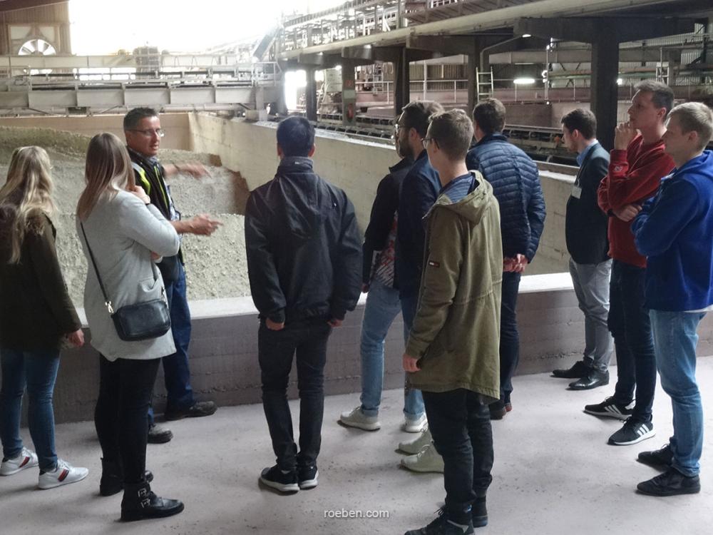 Eine Gruppe von Menschen besichtigt ein industrielles Gebäude.