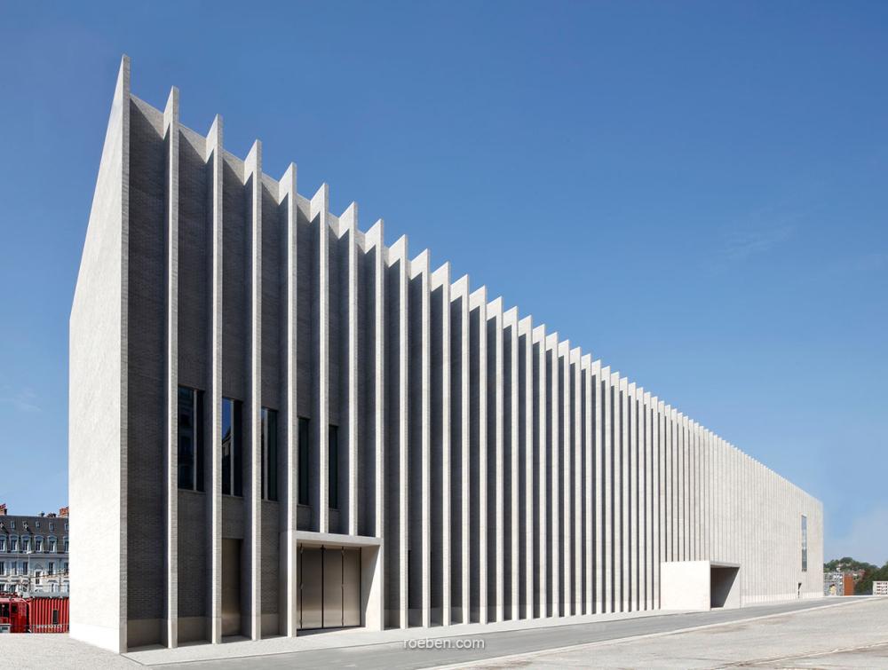 Modernes Gebäude mit markanten vertikalen Linien, klarer Himmel.