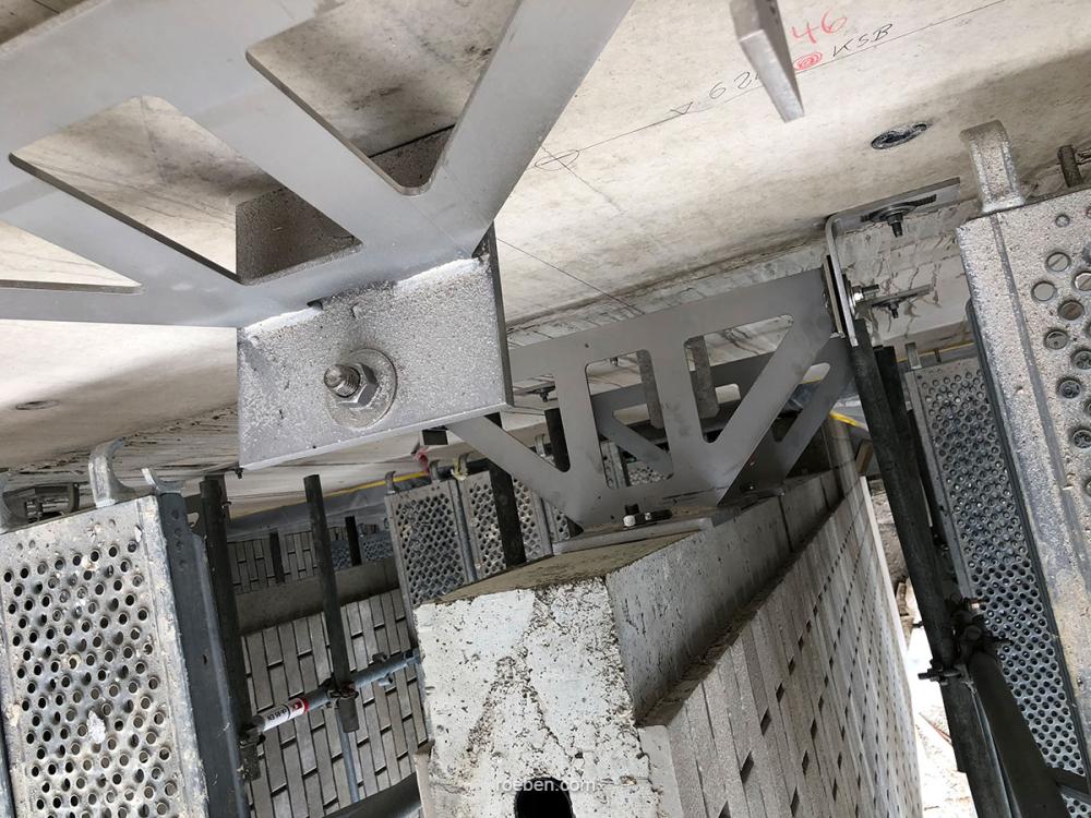 Metallkonstruktion in einem Gebäude, graue Träger und Gitterplatten.