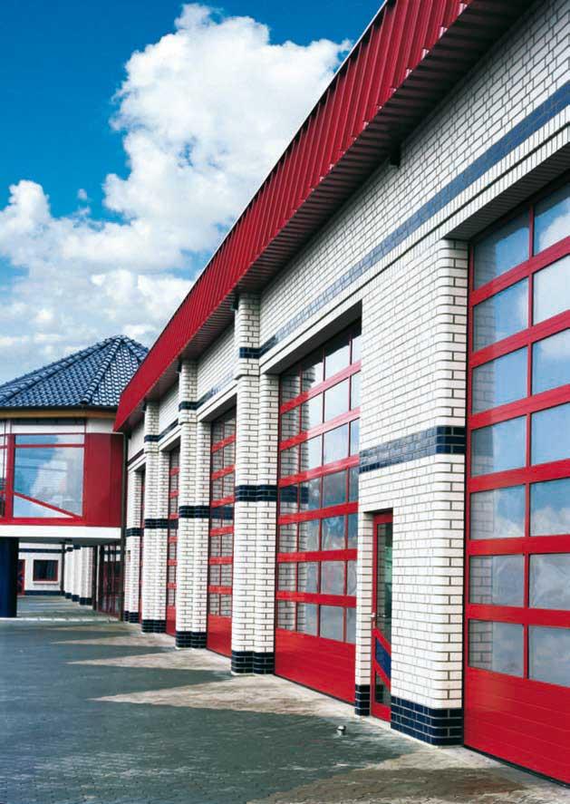 Feuerwache mit roten Toren und blauem Himmel.