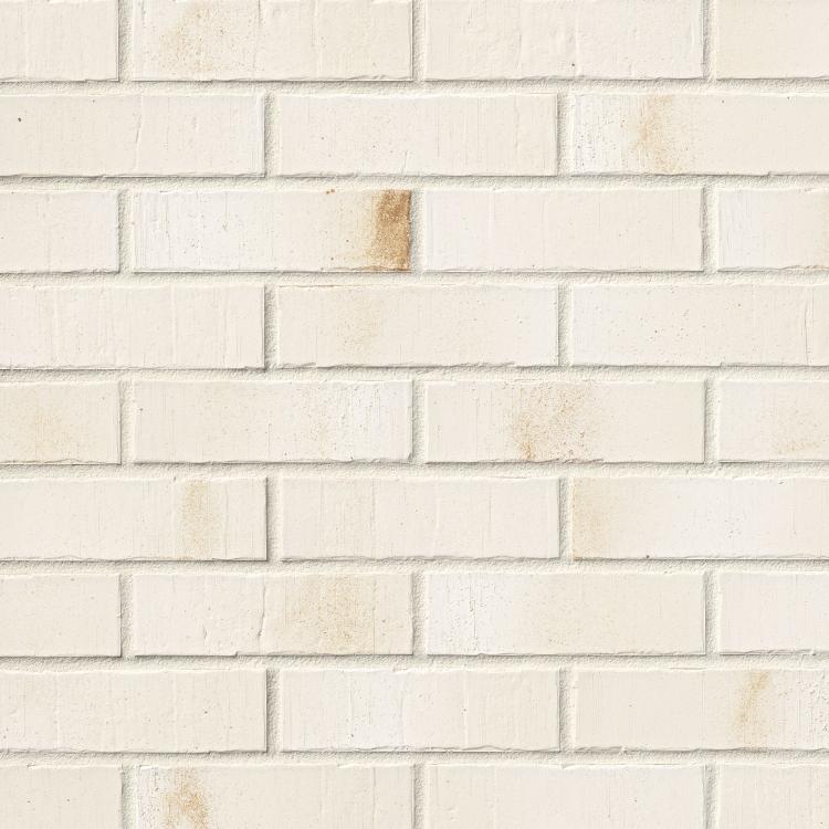 Weiße Ziegelwand mit leichtem Rostfleckenmuster.