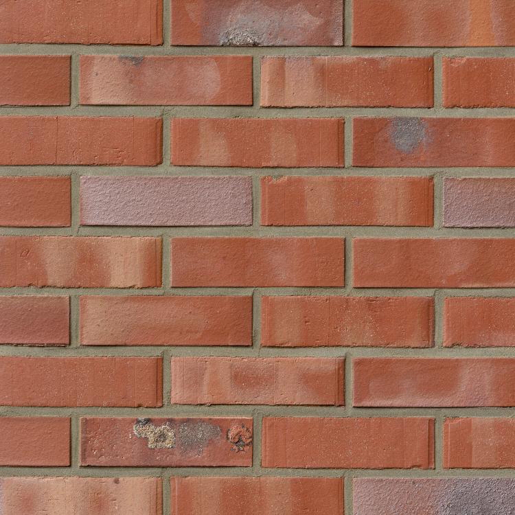 Rote Ziegelsteinmauer mit unregelmäßigen Farbtönen.