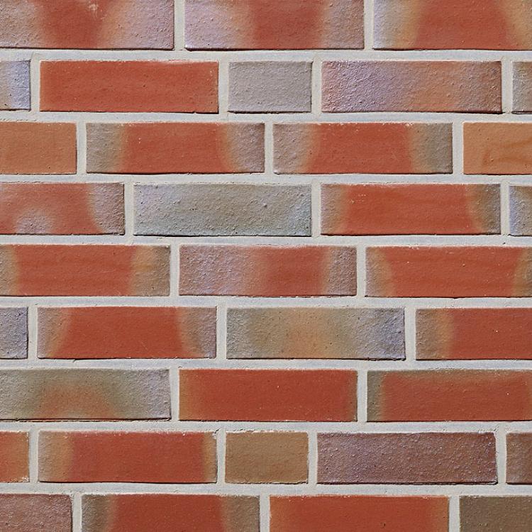 Ziegelmauer mit roten, orangefarbenen und grauen Backsteinen.