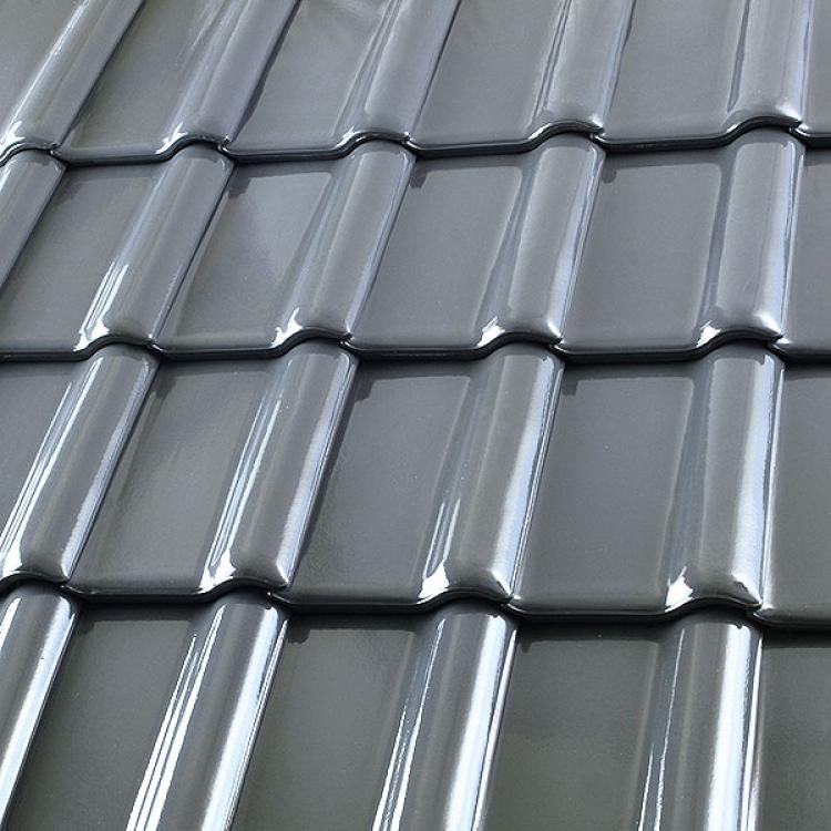 Glänzende schwarze Dachziegel in Reihen.