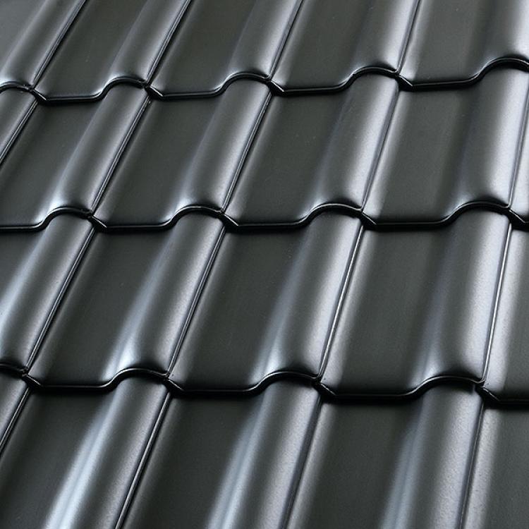 Schwarze Dachziegel aus Metall in Reihen angeordnet.