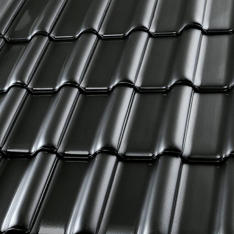 Schwarze, glänzende Ziegel auf einem Dach.