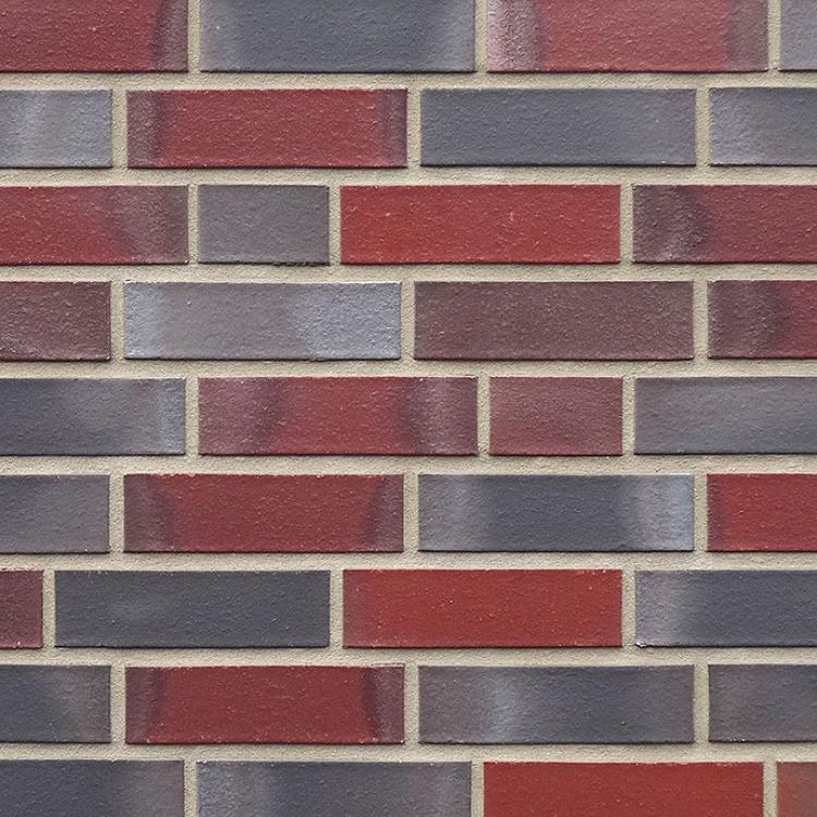 Backsteinmauer aus abwechselnd roten und grauen Ziegelsteinen.