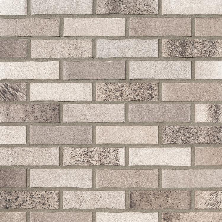 Klinkerwand mit beige und grauen Ziegeln in gleichmäßigem Muster.