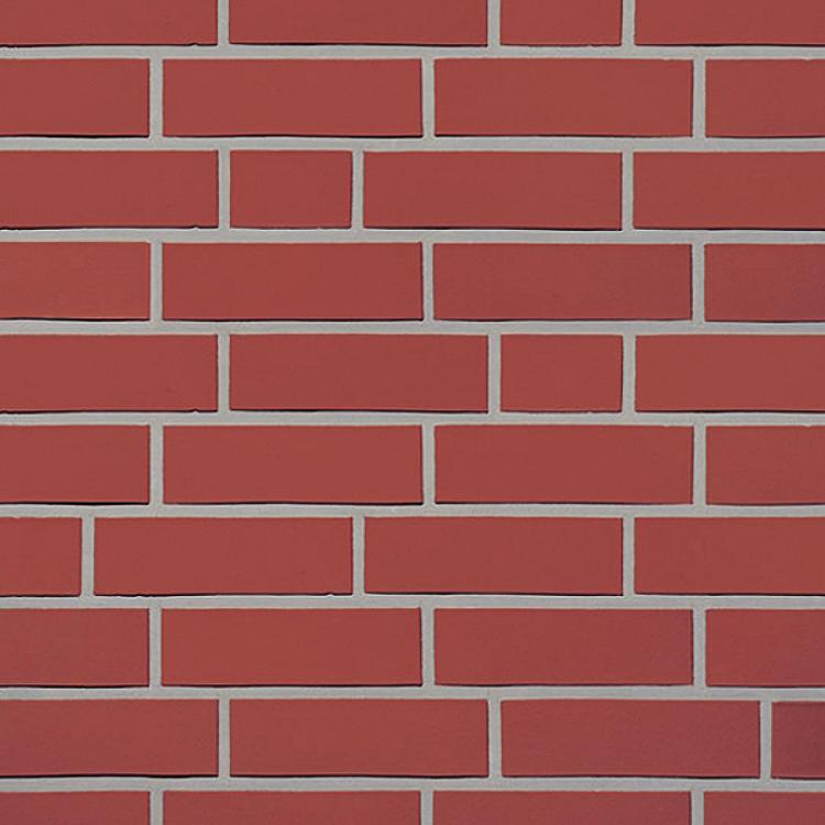 Rote Backsteinmauer mit hellem Fugenmuster.